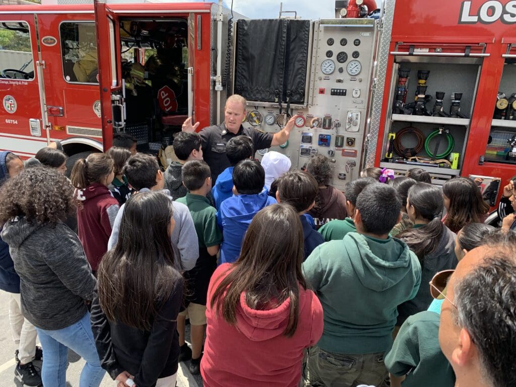 Man giving live presentation about fire engine to school children.