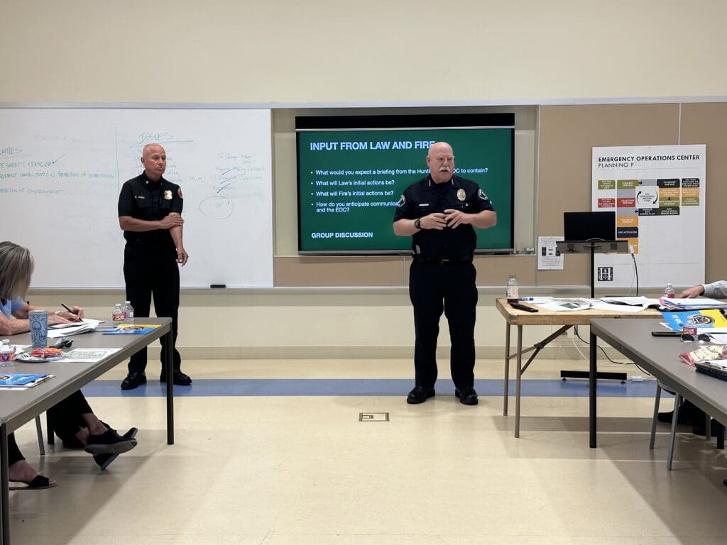 Two male safety officials presenting information to a classroom of people taking notes.