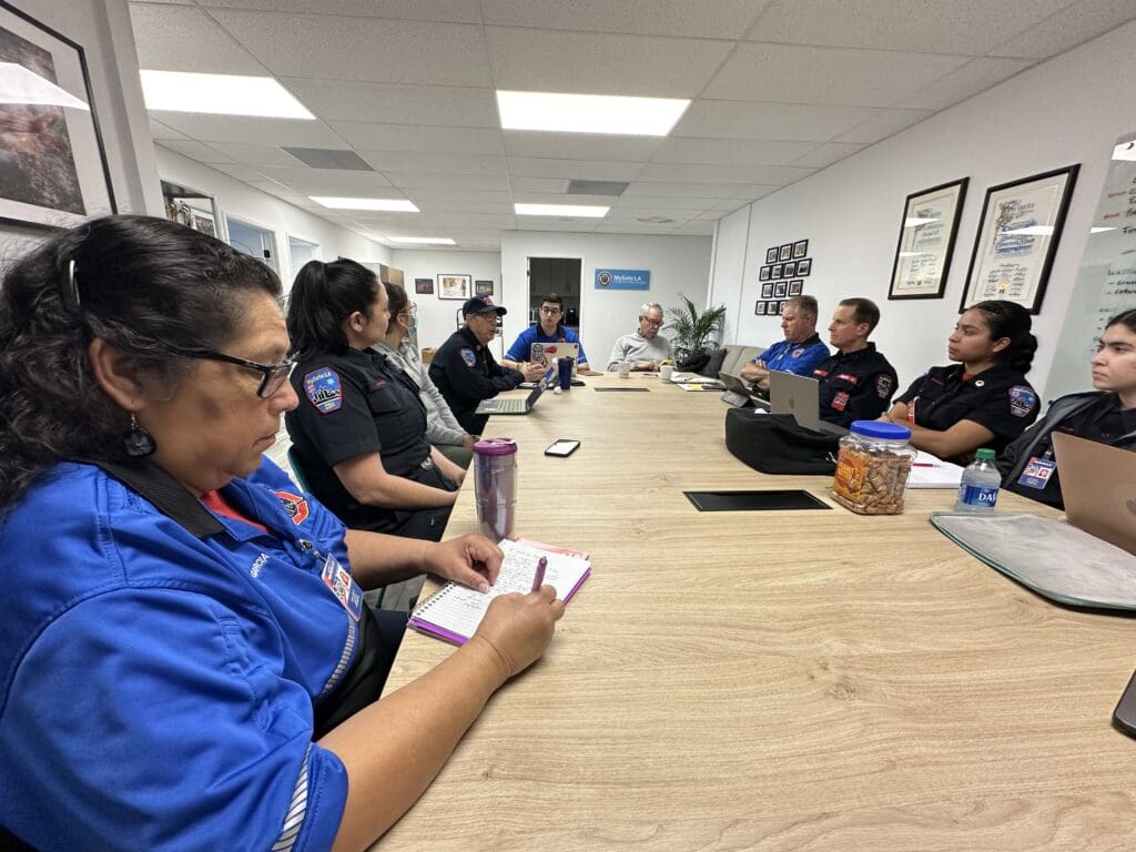 Male and female public safety officials sitting around a conference table during a meeting.